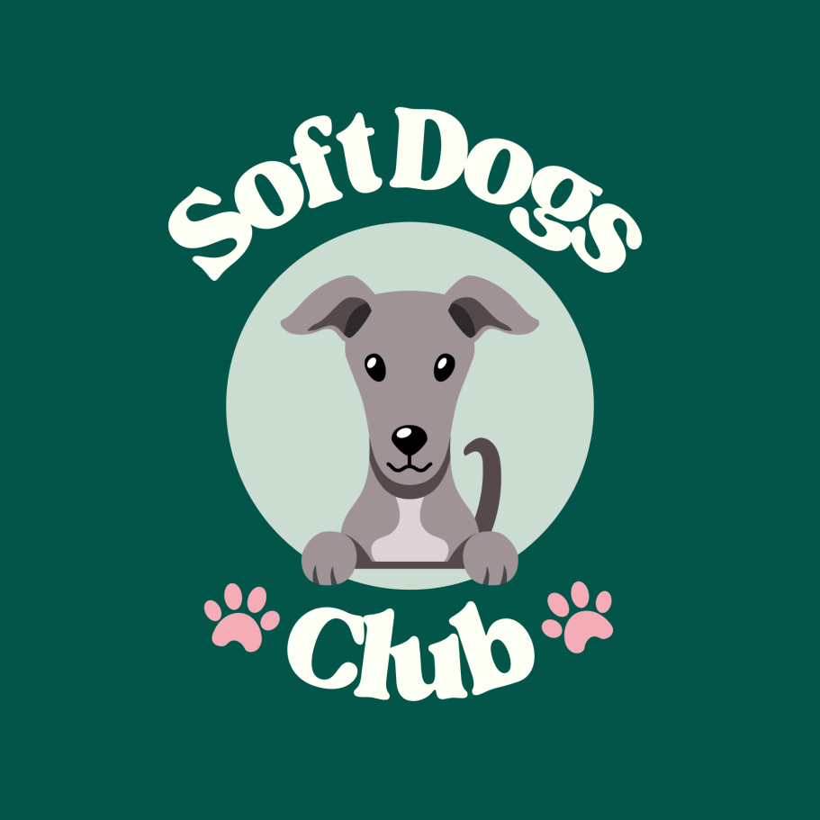 Soft Dogs Club Logo - A grey dog peering out of a light green circle with the words soft dogs club around it and two pink paw prints on either side of the word club.